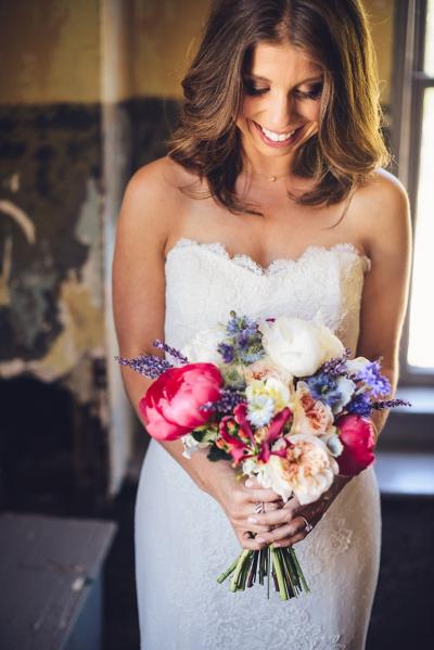 Rachel's vibrant wedding bouquet. She wears Amy Kuschel's Rosemary wedding gown. Photography by Ken Kienow.